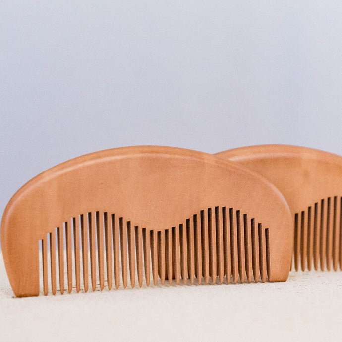 Elegant wooden beard comb from LycanCo, crafted from fine wood with wide and fine teeth, perfect for grooming beards and hair.