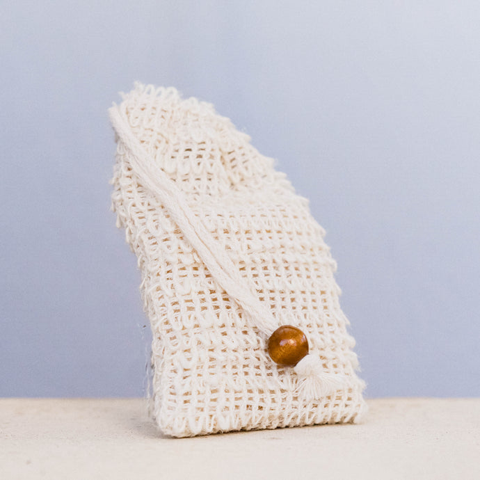Natural hessian soap bag from LycanCo, featuring a drawstring closure and wooden bead, ideal for exfoliating and storage.