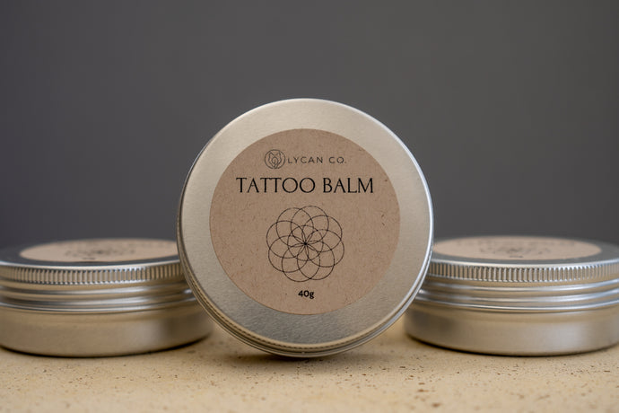 LycanCo Tattoo Balm in a circular tin, designed to enhance tattoo healing and brightness, displayed against a neutral backdrop.