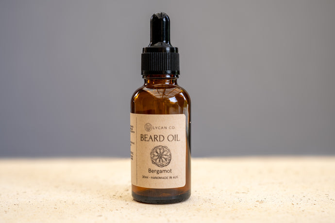 LycanCo Bergamot Beard Oil bottle on a marble countertop, highlighting its vibrant, citrus scent.
