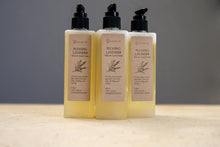 Load image into Gallery viewer, Trio of LycanCo Pleasing Lavender Liquid Soap bottles displayed against a calm grey backdrop, emphasizing the soothing lavender essence.