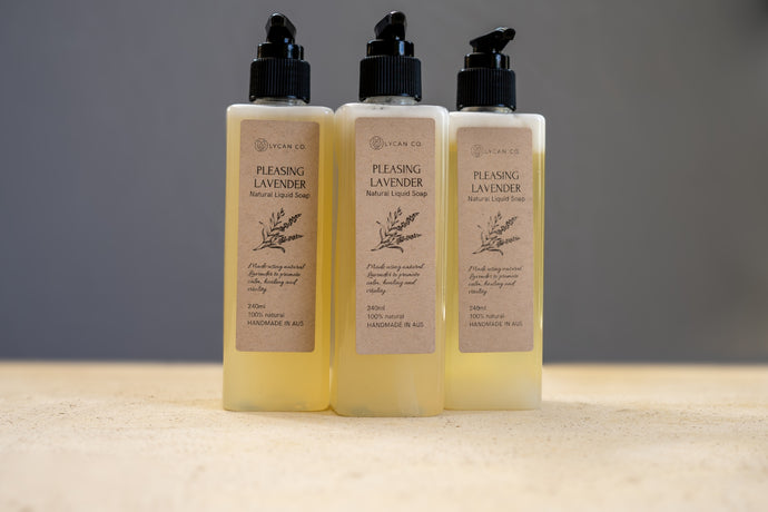Trio of LycanCo Pleasing Lavender Liquid Soap bottles displayed against a calm grey backdrop, emphasizing the soothing lavender essence.